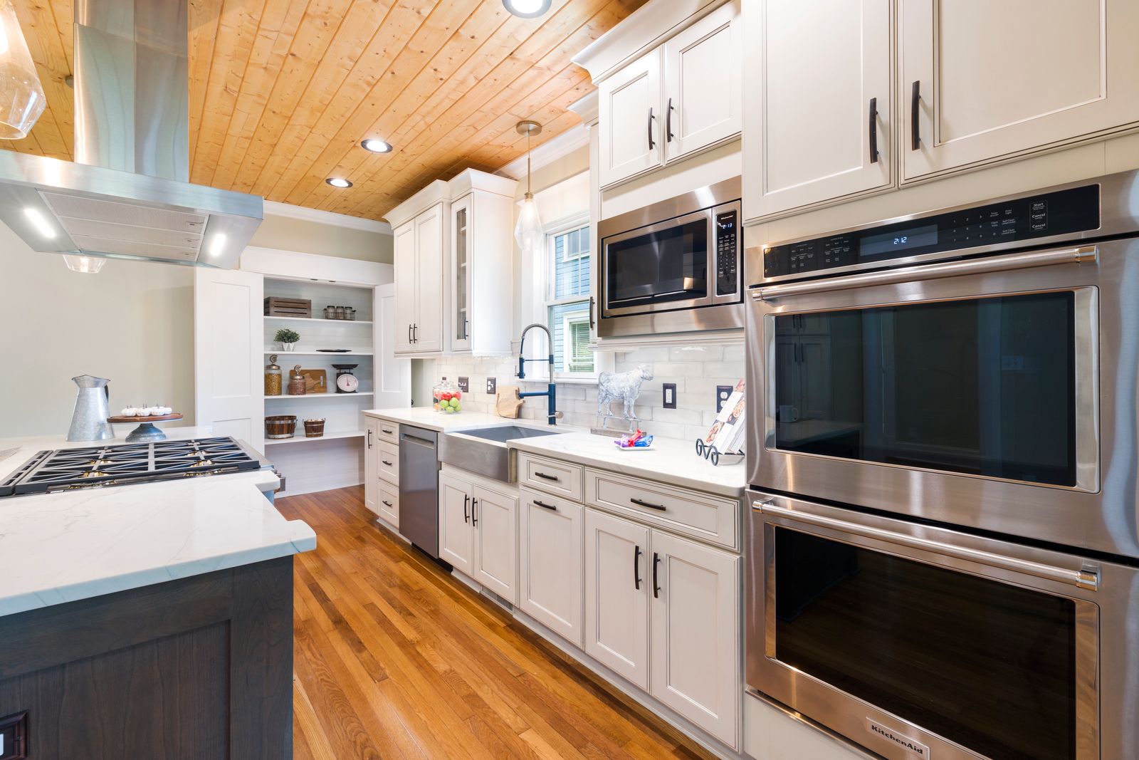 Kitchen after renovation, finished cabinetry and hardwood floor